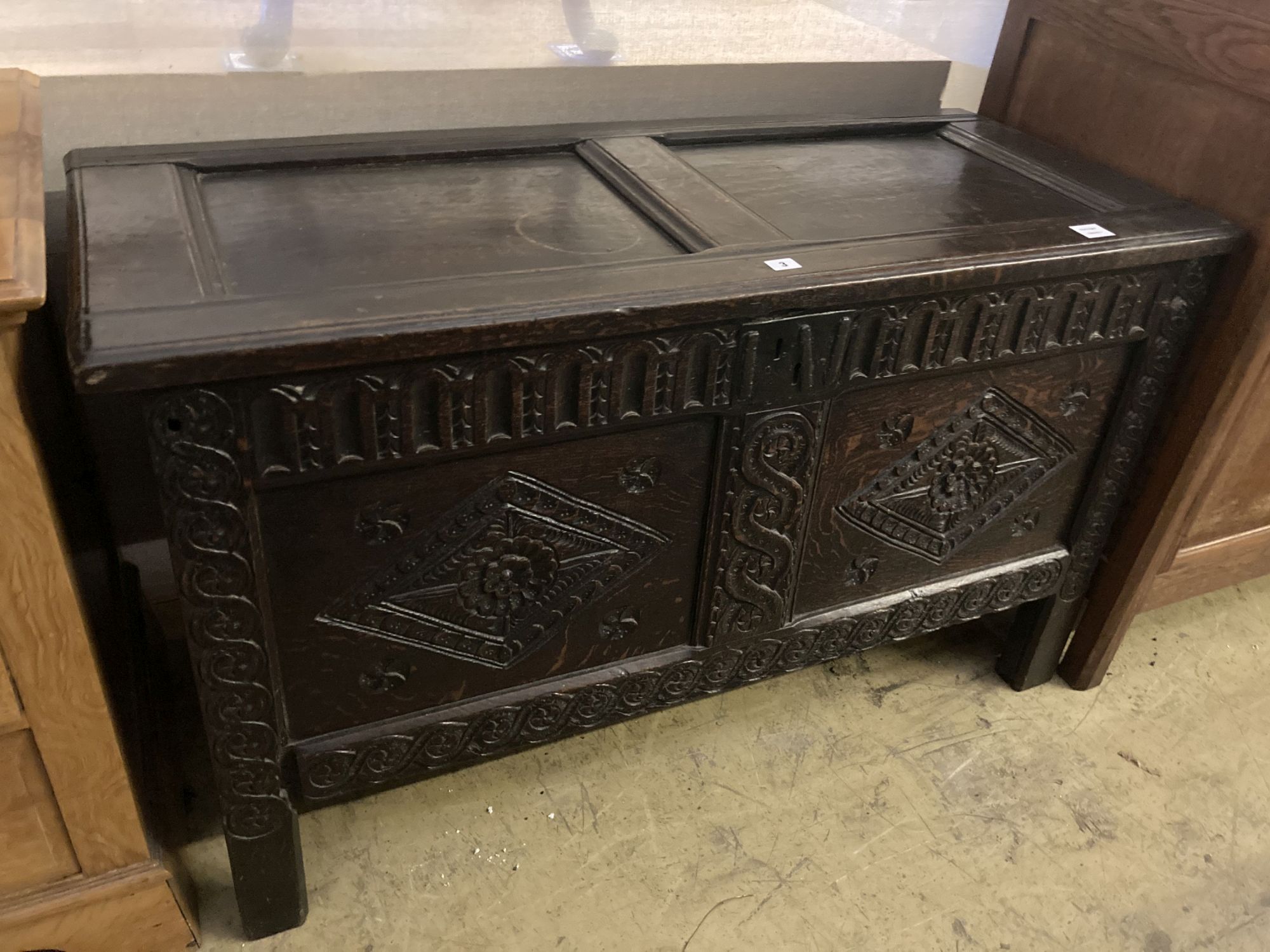 An 18th century carved oak coffer with twin panelled front, width 125cm, depth 55cm, height 75cm